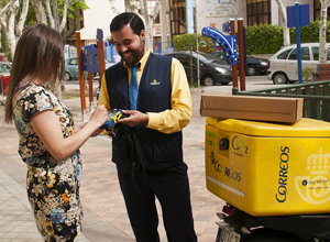 Repartidor de CORREOS entrega un paquete a una mujer